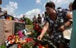Ucranianos depositan flores durante una ceremonia en el sitio donde cayó el vuelo MH17, en el quinto aniversario del desastre.