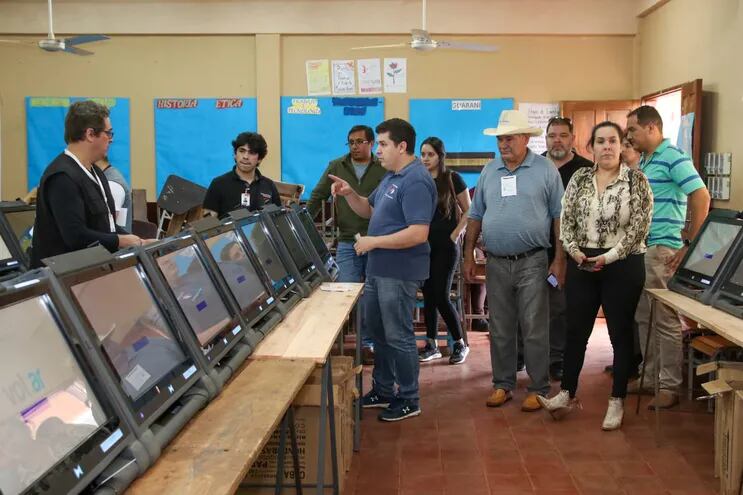 Funcionarios del TSJE revisando las máquinas de votación que se utilizarán hoy en las Elecciones Complementarias 2023.