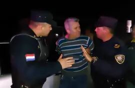 El abogado Edgar Daniel Cáceres Báez (centro) abordado por los uniformados que intentan calmarlo.