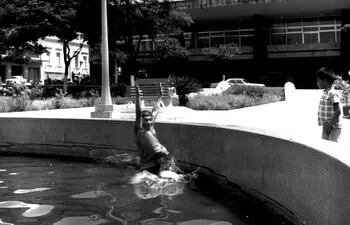 Aplacando el sofocante calor del verano de 1969-1970 en la fuente de la plaza, frente al Hotel Guaraní.