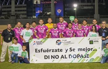 El Equipo de Juego Limpio posa con la escuadra principal del club Libertad.