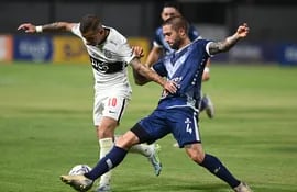 Derlis González (i), atacante de Olimpia, pelea el balón contra el defensor de Sportivo Ameliano en el partido de la séptima jornada del torneo Apertura 2022.